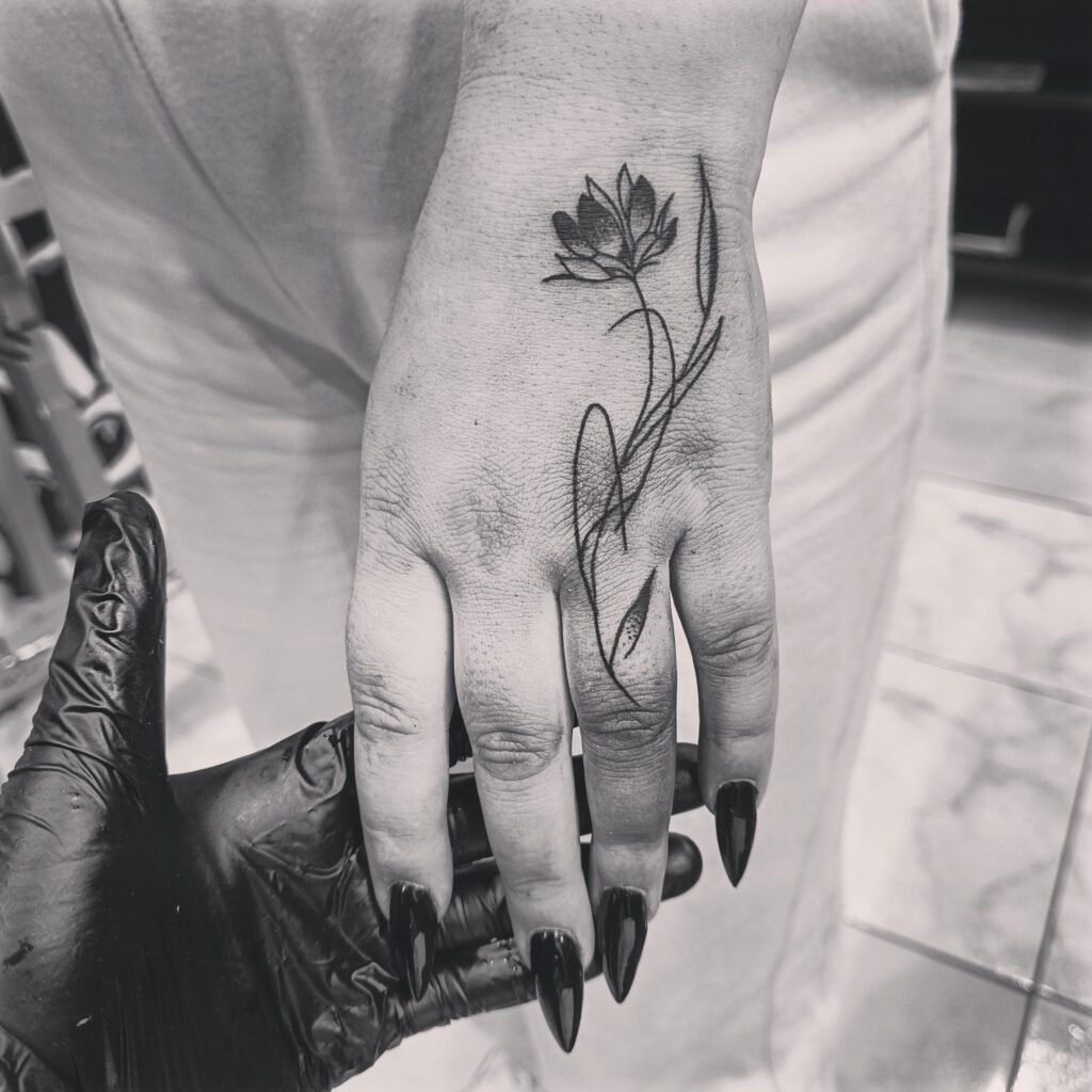 Minimal flower hand tattoo 🖤 At @tattoosclub23, athens.